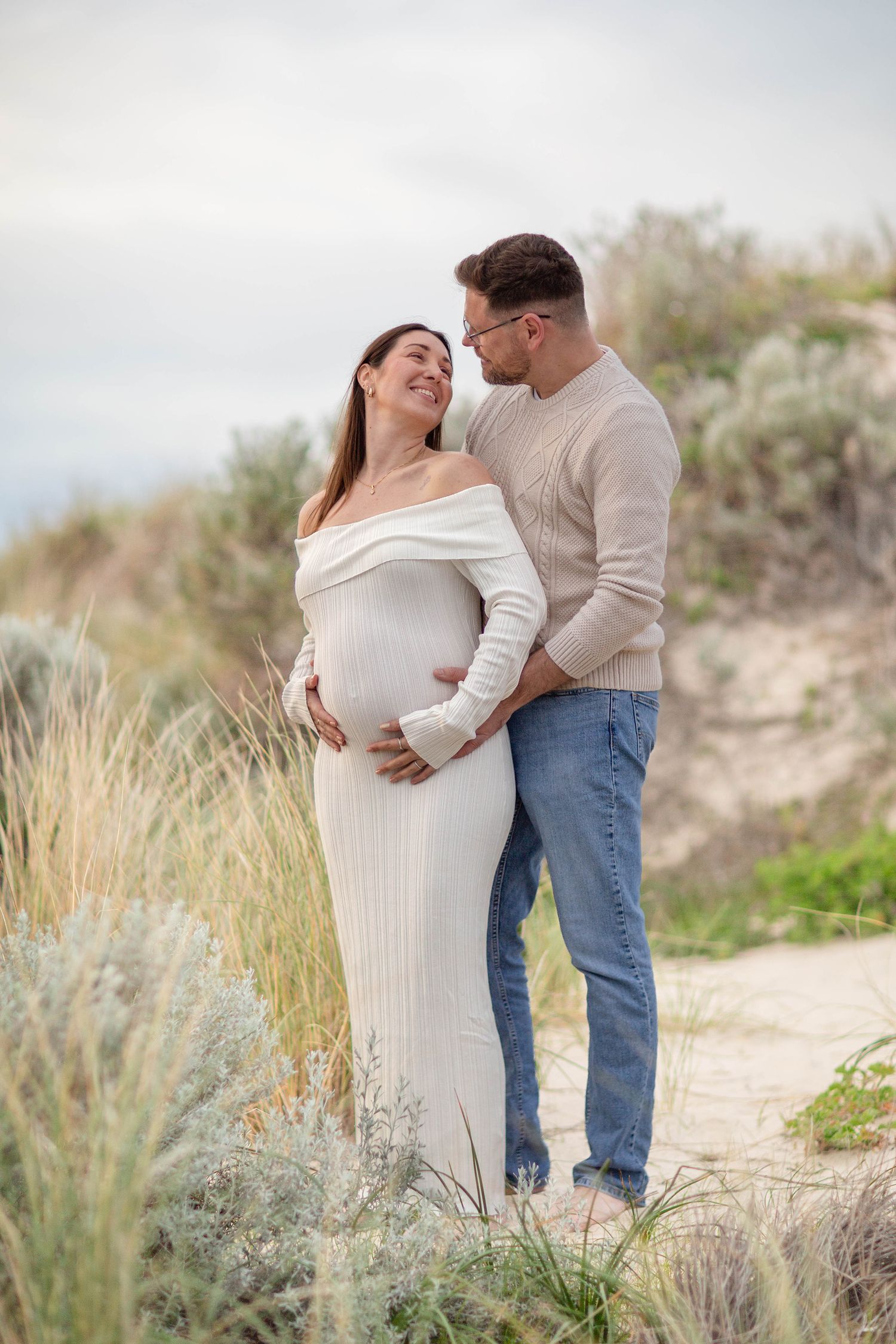 Couple embracing and having a moment during their maternity session at golden hour on the beach in perth