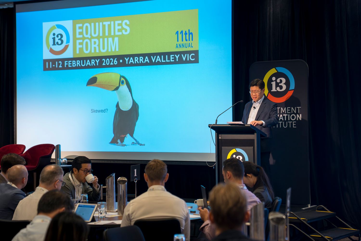 Speaker presenting at i3 Equities Forum 11th Annual event, 11-12 February 2026, Yarra Valley VIC, to seated audience.