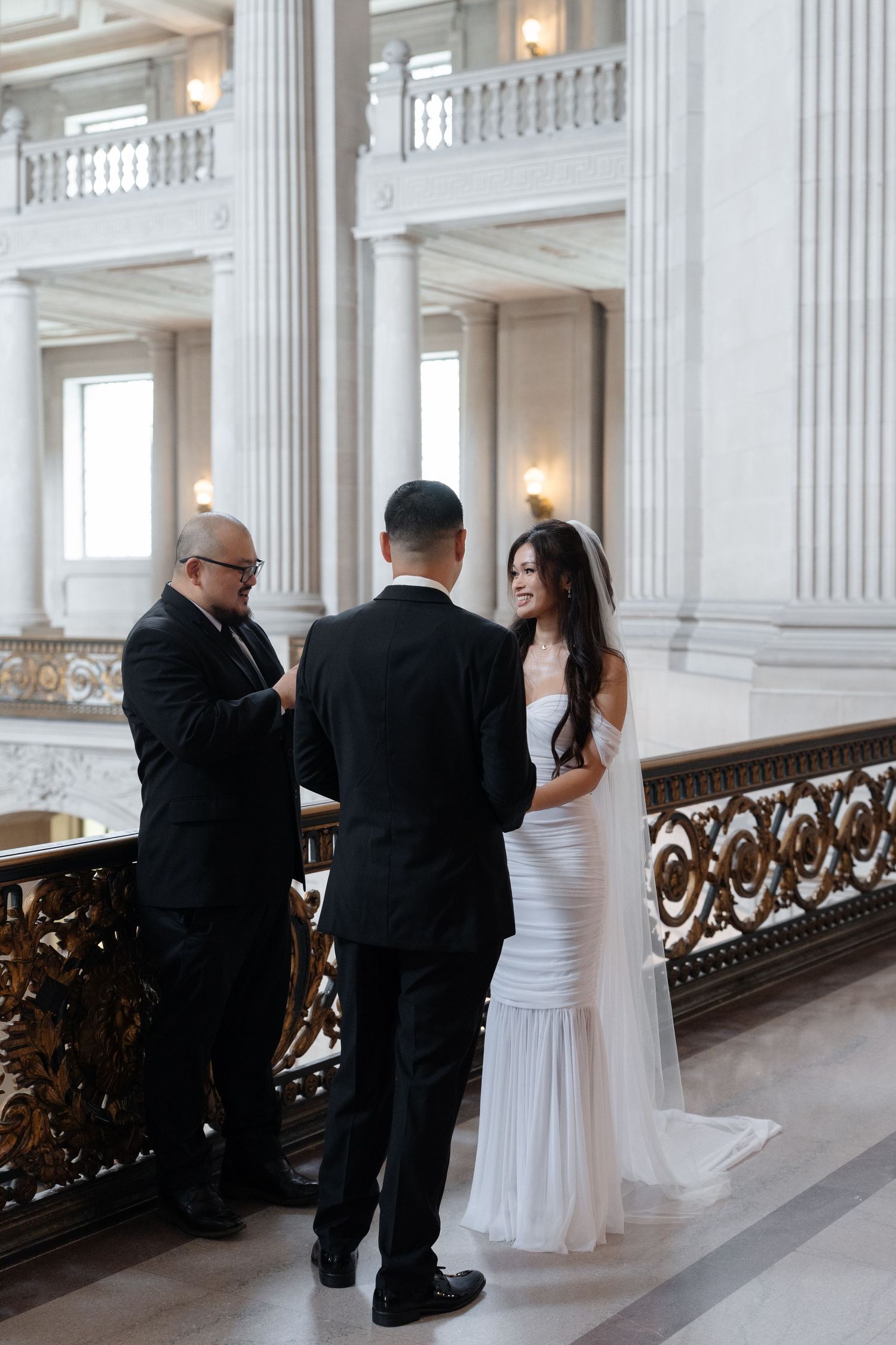 Bride and groom exchange vows with officiant at San Francisco City Hall wedding ceremony.