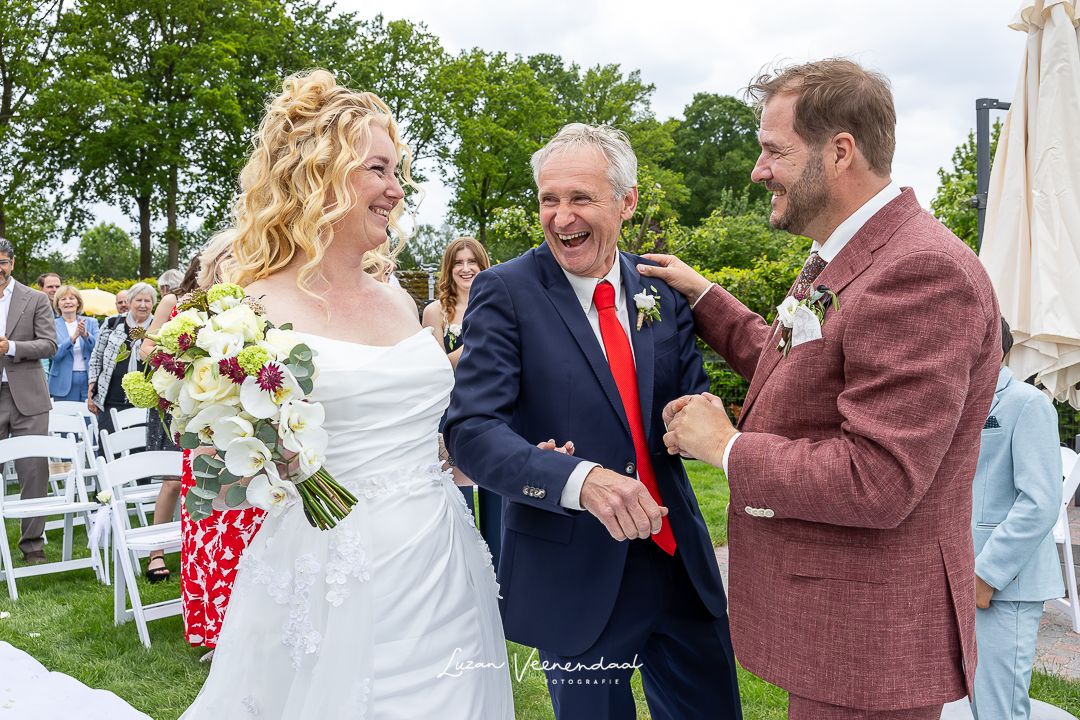 Madelief wordt door haar lachende vader aan Vincent gegeven tijdens de ceremonie