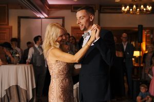 Mother and son share an emotional first dance at a wedding reception in an elegant ballroom.