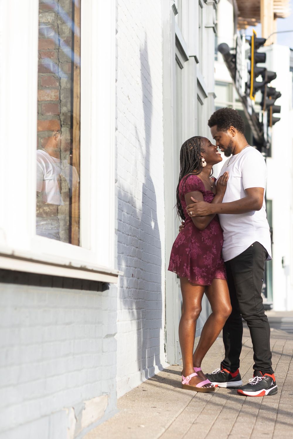 A young couple sharing a romantic kiss during couple session in downtown Lexington with wedding photographer.