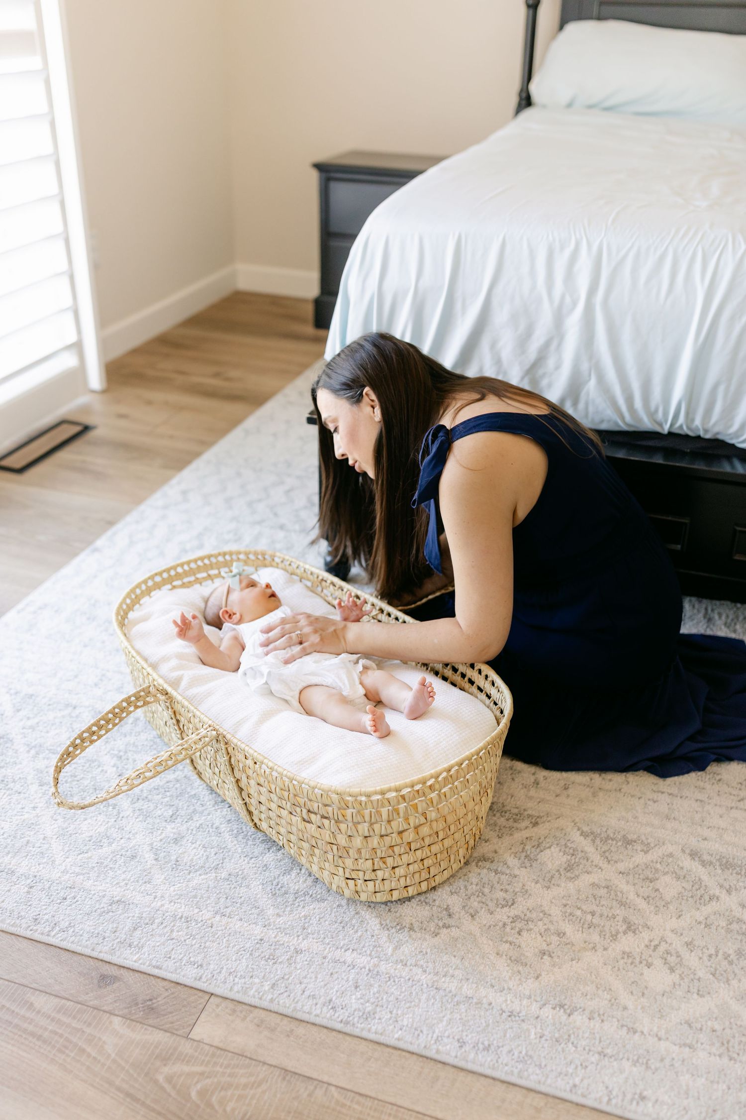 Family on bed with newborn baby, toddler on dad's shoulders, mom smiling, lifestyle newborn photography.