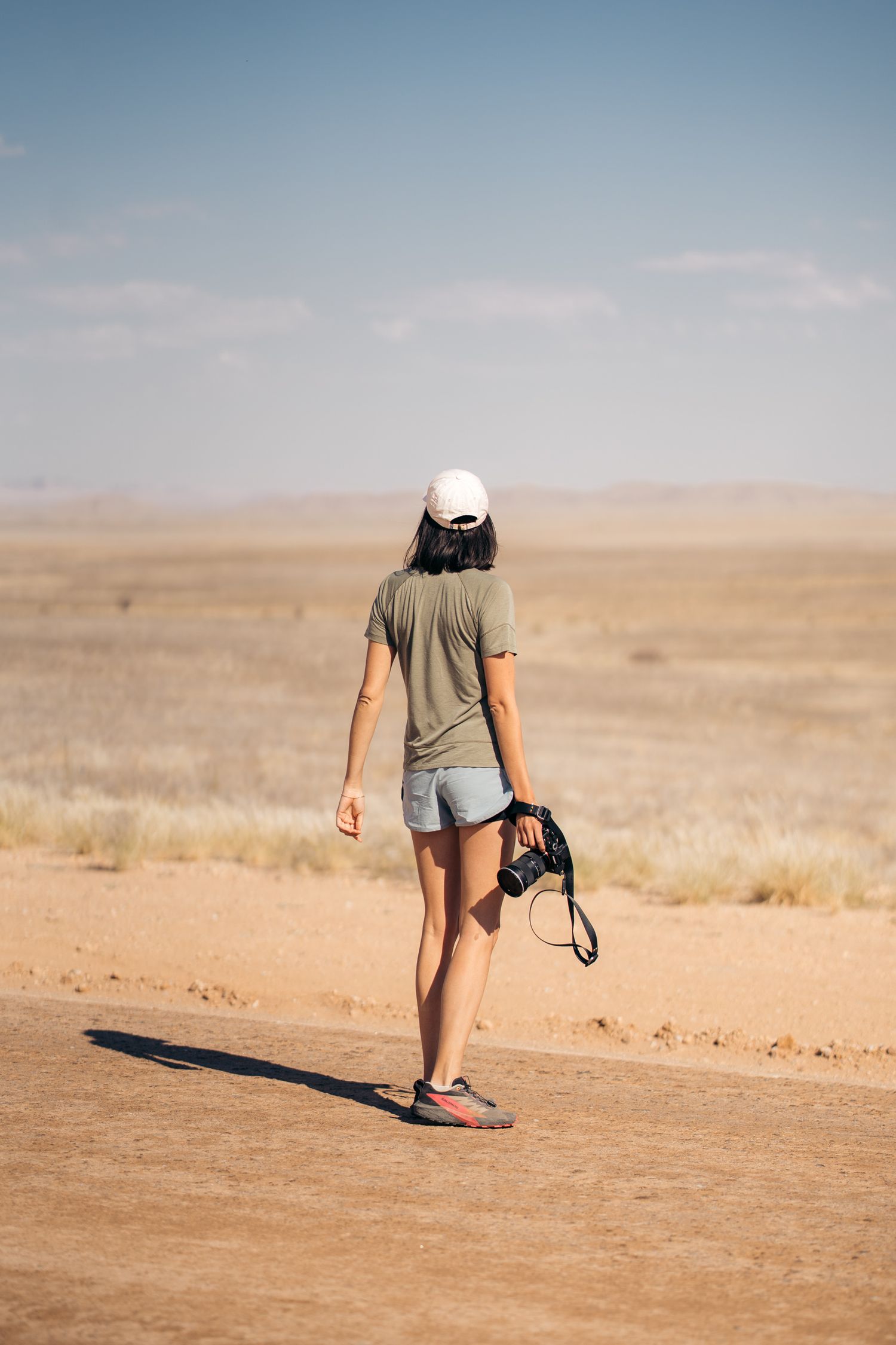 photographe de dos sur les piste en gravier de namibie