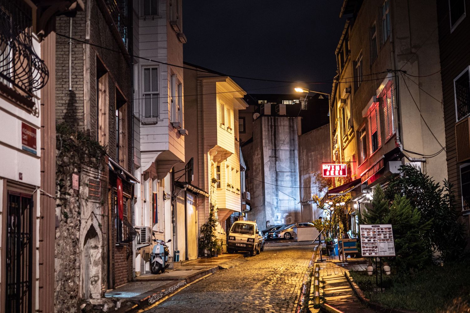 Small city streets of Istanbul after the rain with reflecting neon lights.