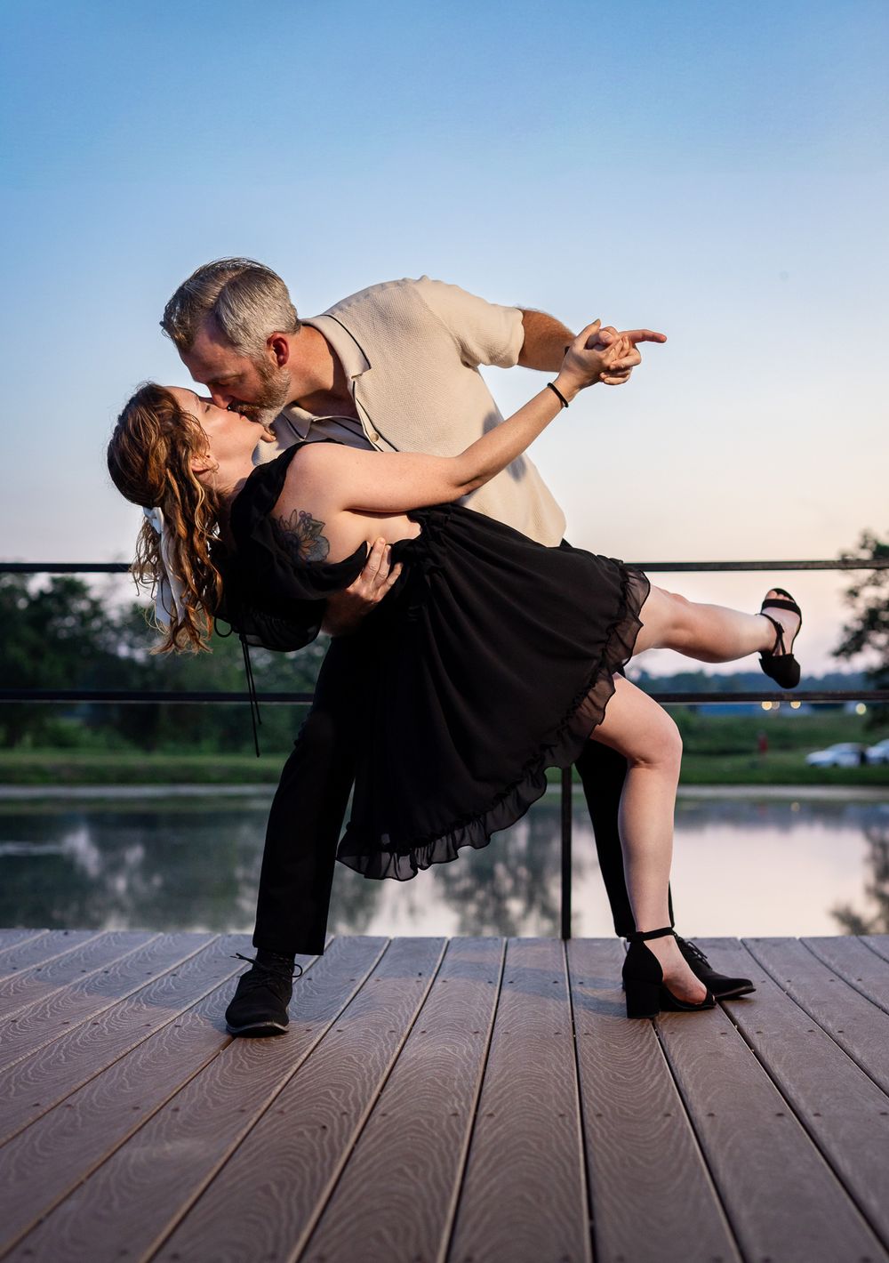 Couple in a romantic sunset dip pose by the water during a couples photography session in Mountain Home, Arkansas