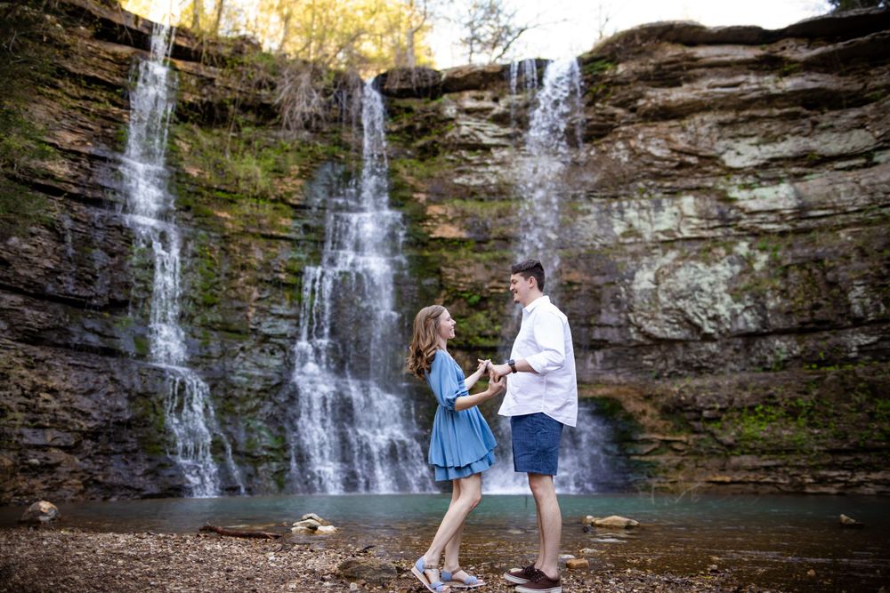 Couple standing together at the base of Triple Falls waterfall during a couples session in Jasper, Arkansas