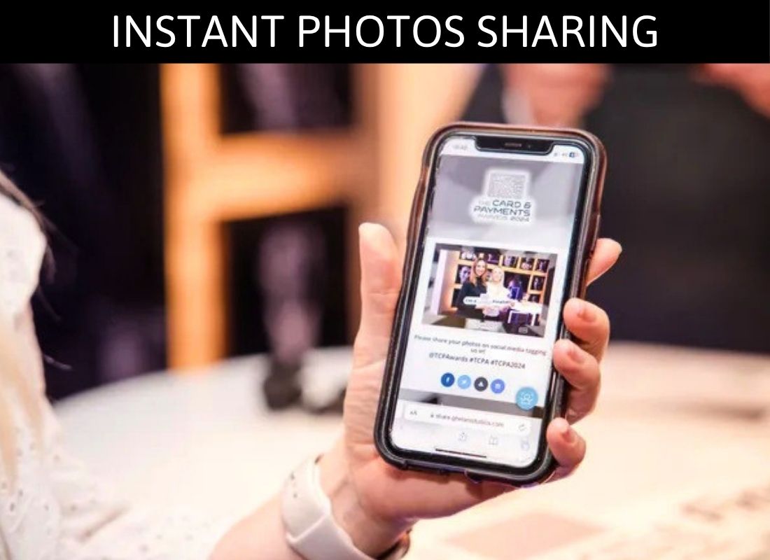 Person holding smartphone displaying instant photo sharing feature at an event venue.
