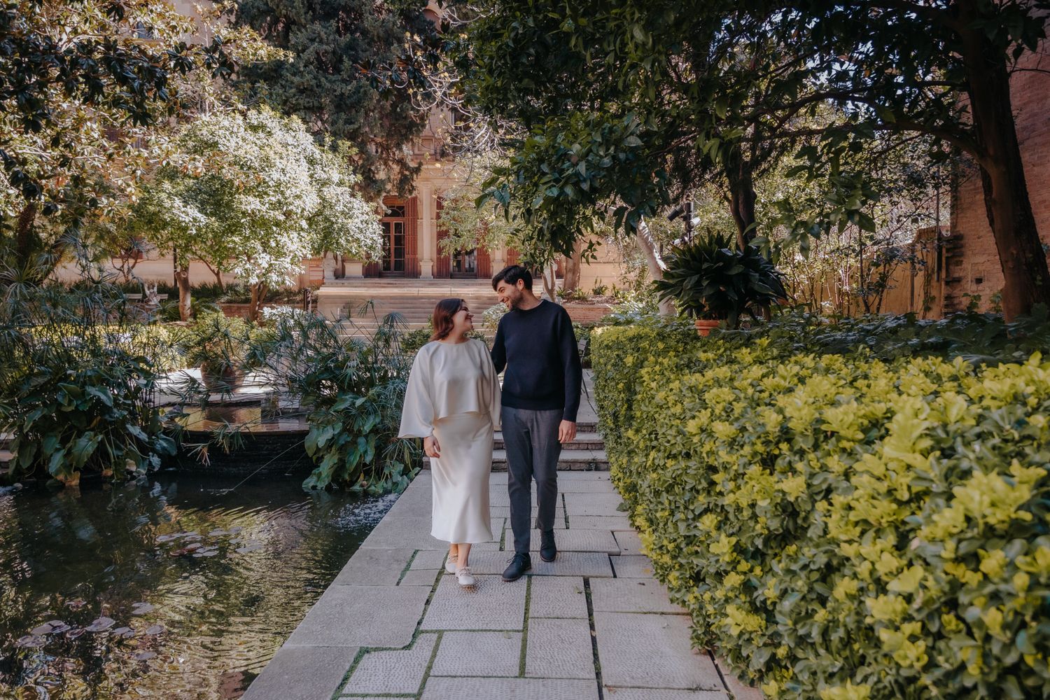 Tender hug between a couple in the hidden garden of Julio Munoz Ramonet, lit by soft early morning sun