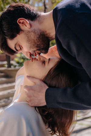 Romantic couple gazing at each other in the beautiful, sunlit public garden of Jardin Julio Munoz Barcelona