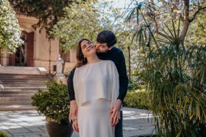 Candid couple laughing with beautiful neoclassical details and lush foliage behind them at Jardin Julio Munoz