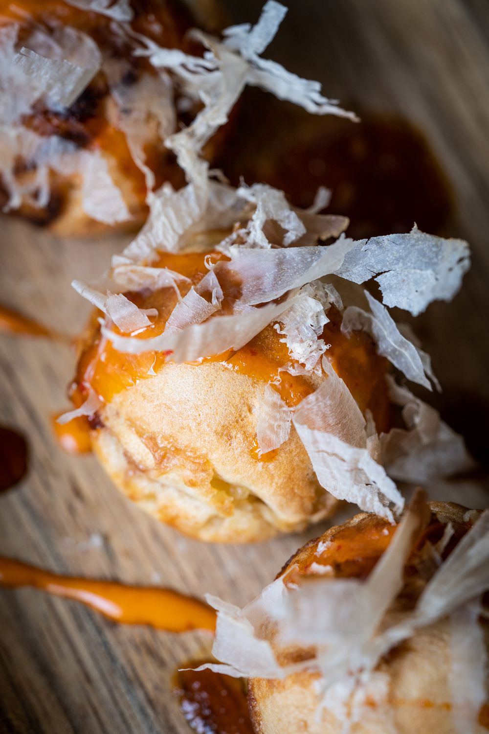 Close-up macro photo of flaky white coconut shavings on top of a golden brown pastry or dessert.