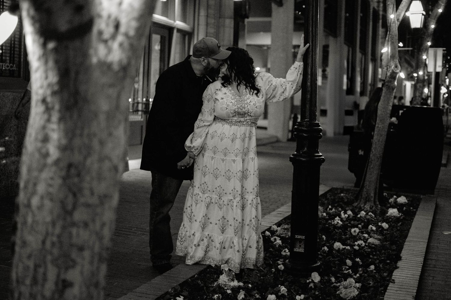Black and white courthouse wedding portrait of newlyweds on a downtown Fort Worth sidewalk at night.