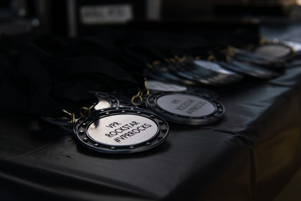 Close-up of award medals with black ribbons displayed on a dark surface at an event ceremony.