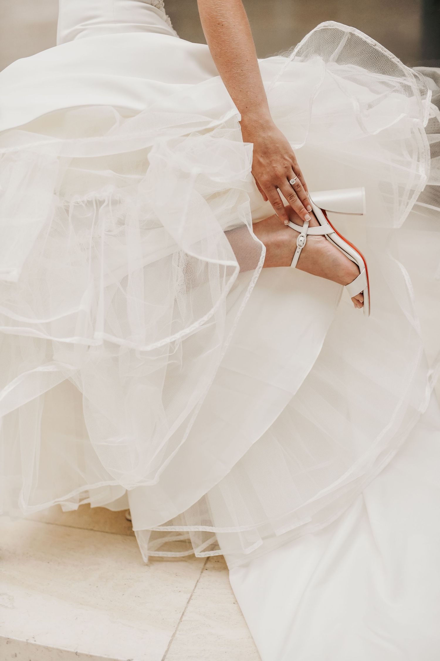Bride showing the detailed close up of her shoes under her gown during her Meyerson bridal session
