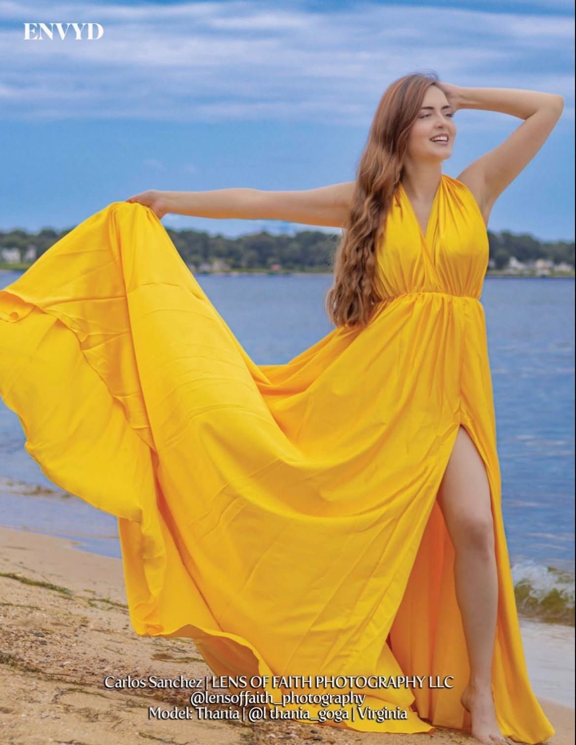 woman in a flowing yellow halter-neck maxi dress standing on a sandy beach with the ocean in the background