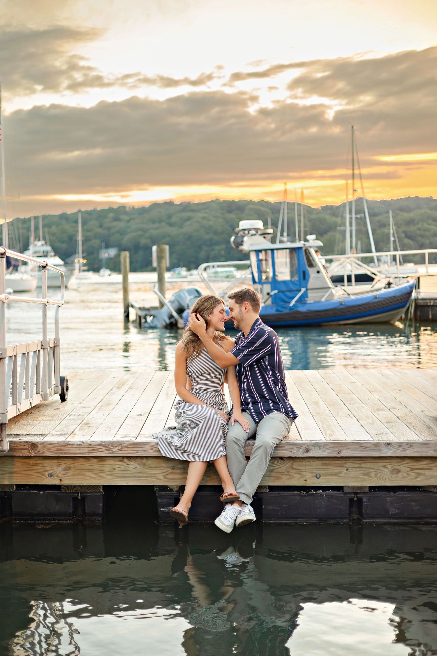 A romantic proposal scene set between rows of grapevines in a scenic vineyard with white flowers and a blanket.