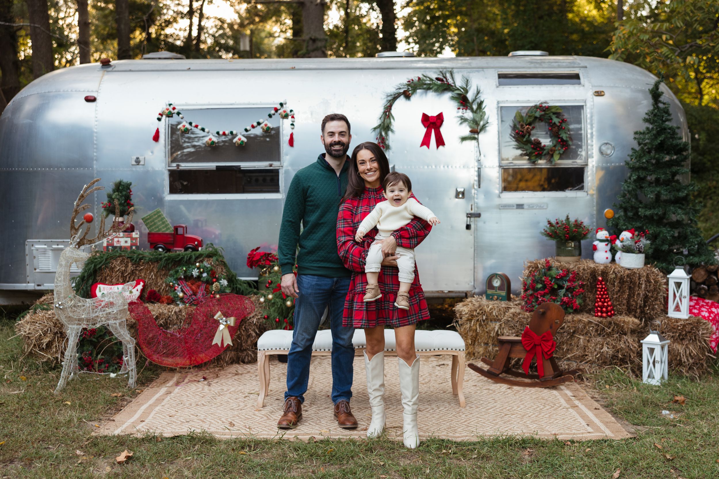 Family posing before decorated Airstream trailer with Christmas decor, at Root and Rise in Medford, NJ.