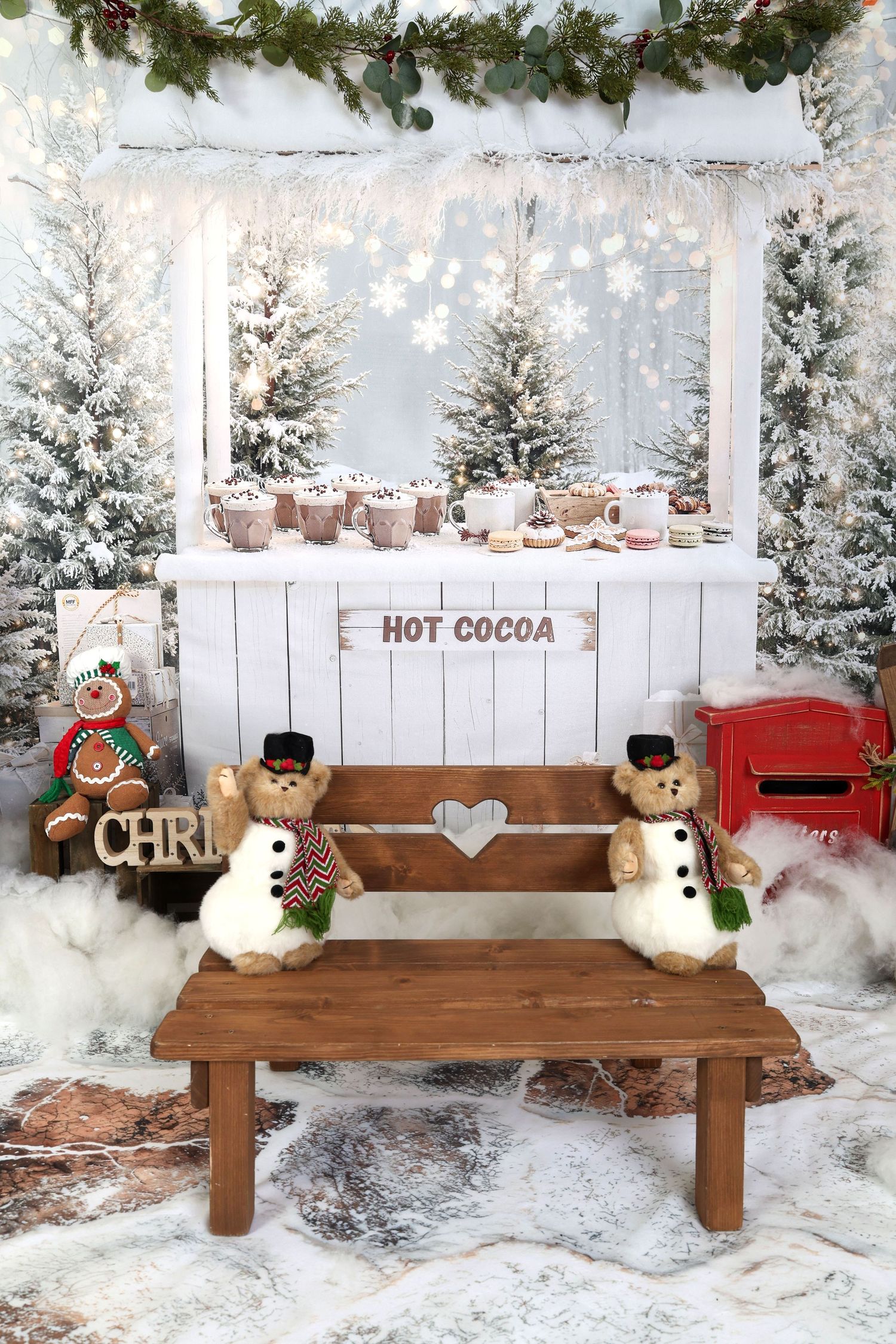 Festive winter scene with snowman figurines on a wooden bench beside a hot cocoa stand with snowy trees and holiday decor.