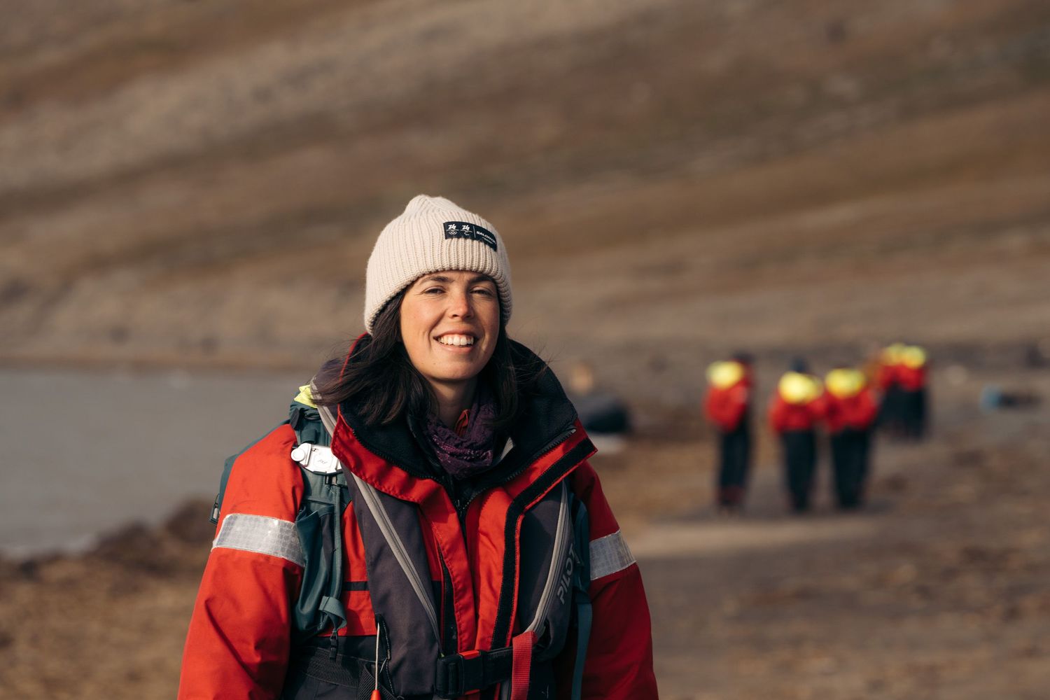 Passagère souriante en combinaison rouge après le débarquement à Kapp Lee