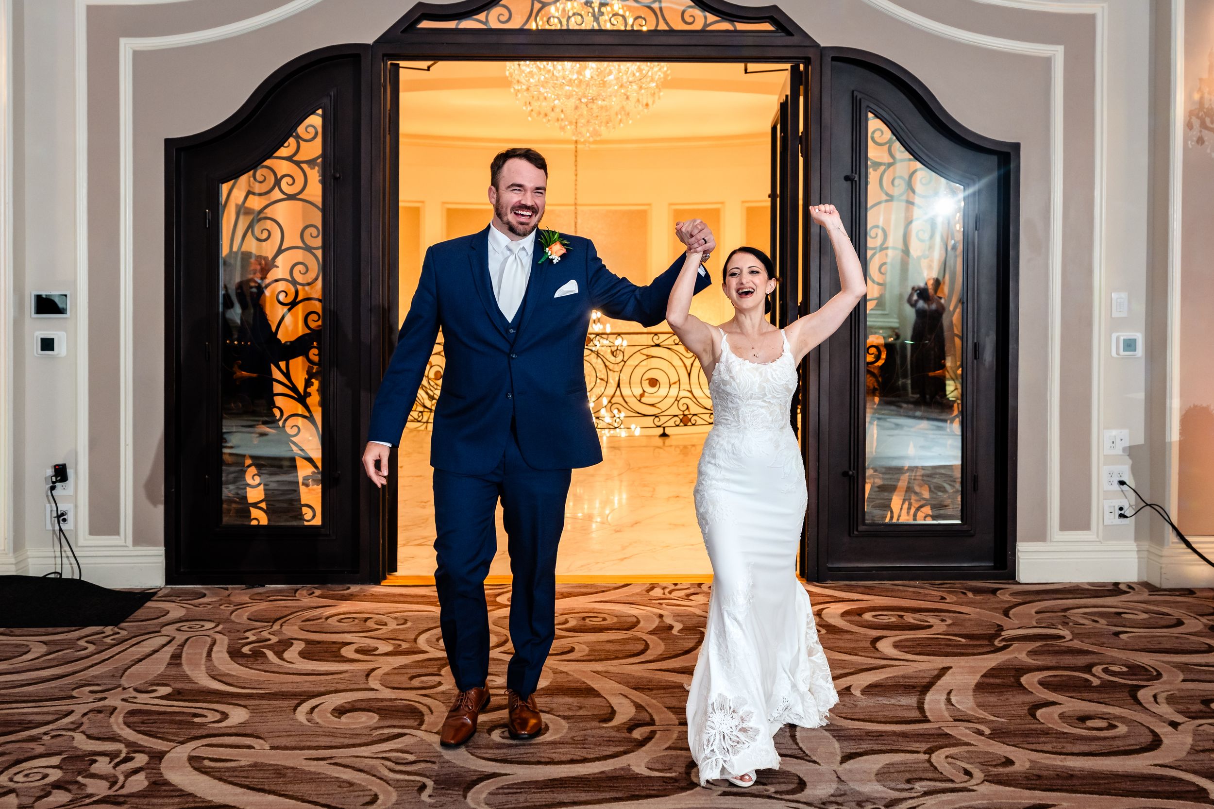 Joyful bride and groom making grand entrance at elegant wedding reception venue.