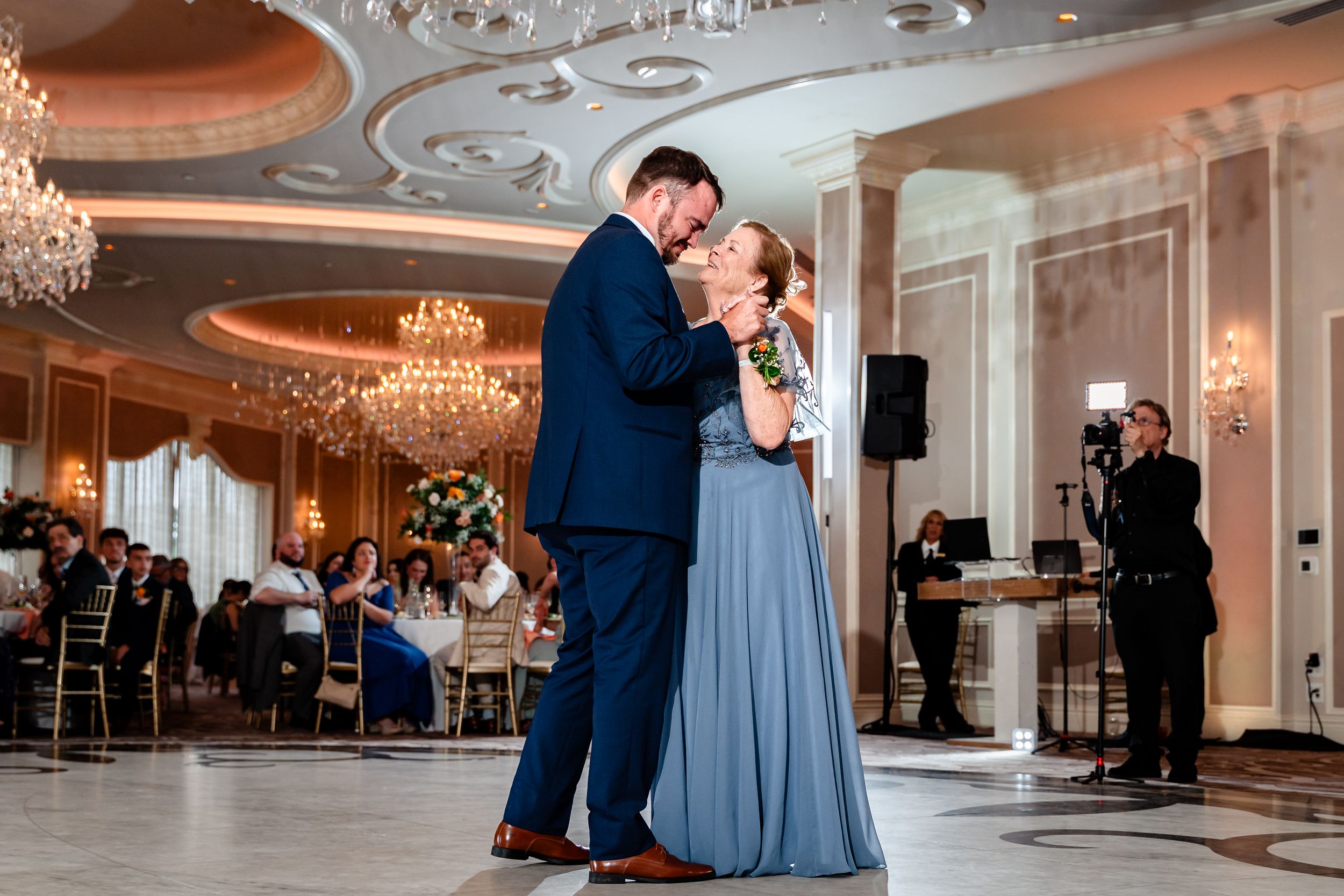Couple sharing romantic first dance in stunning ballroom at wedding reception.