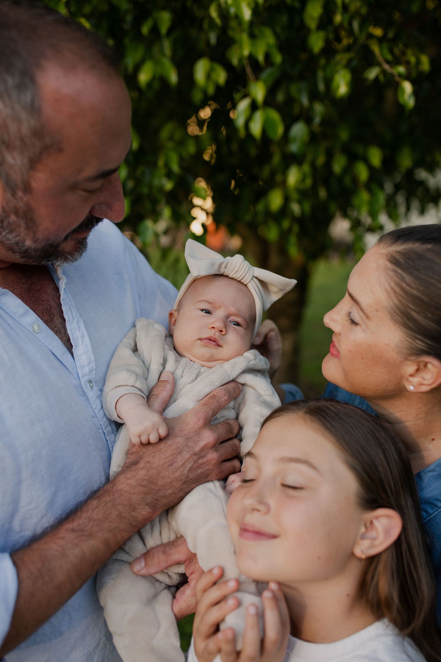 Family photo session in Queensland, Close up of mum, dad, baby and sister. Lush, rural green.