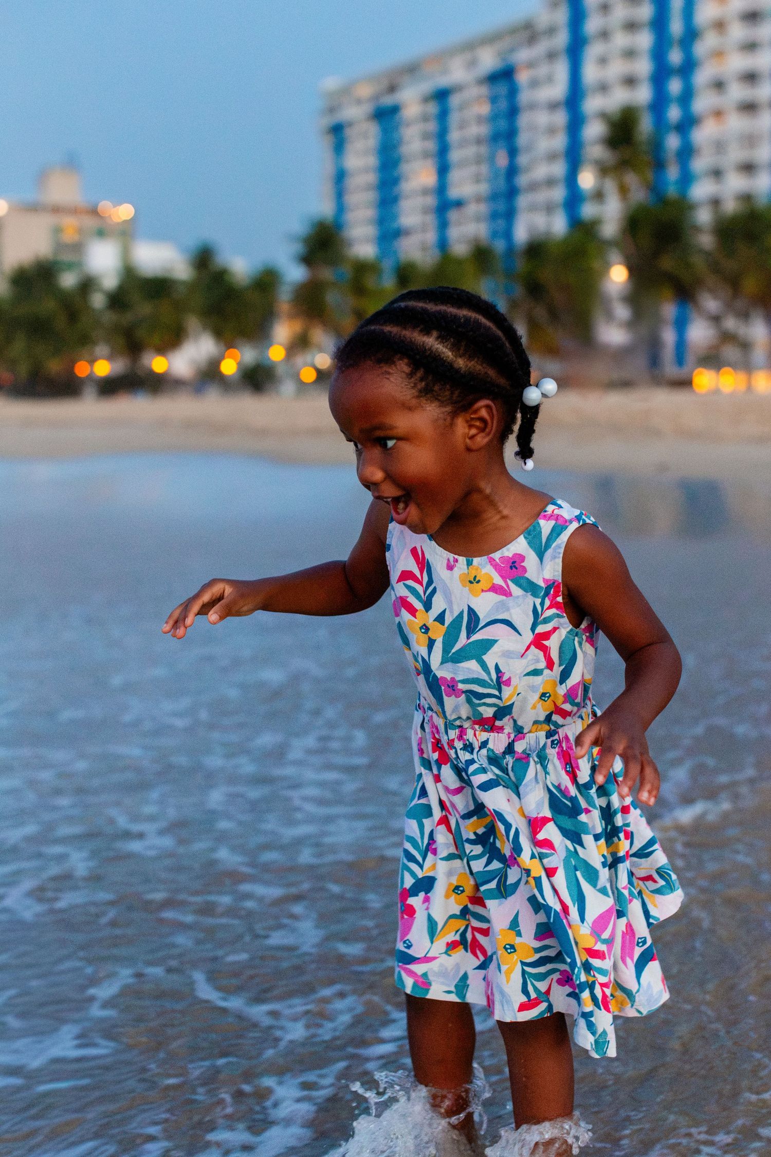 Portrait of a little girl wading in the ocean at the beach in Isla Verde, Carolina, Puerto Rico.