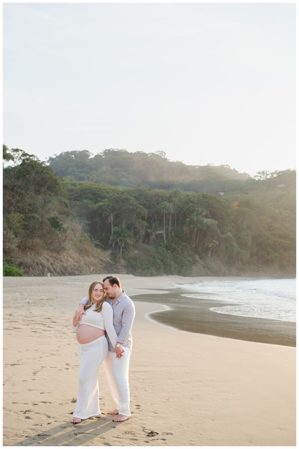 One & Only Mandarina family photographer capturing maternity photos for a couple during a beach sunset.