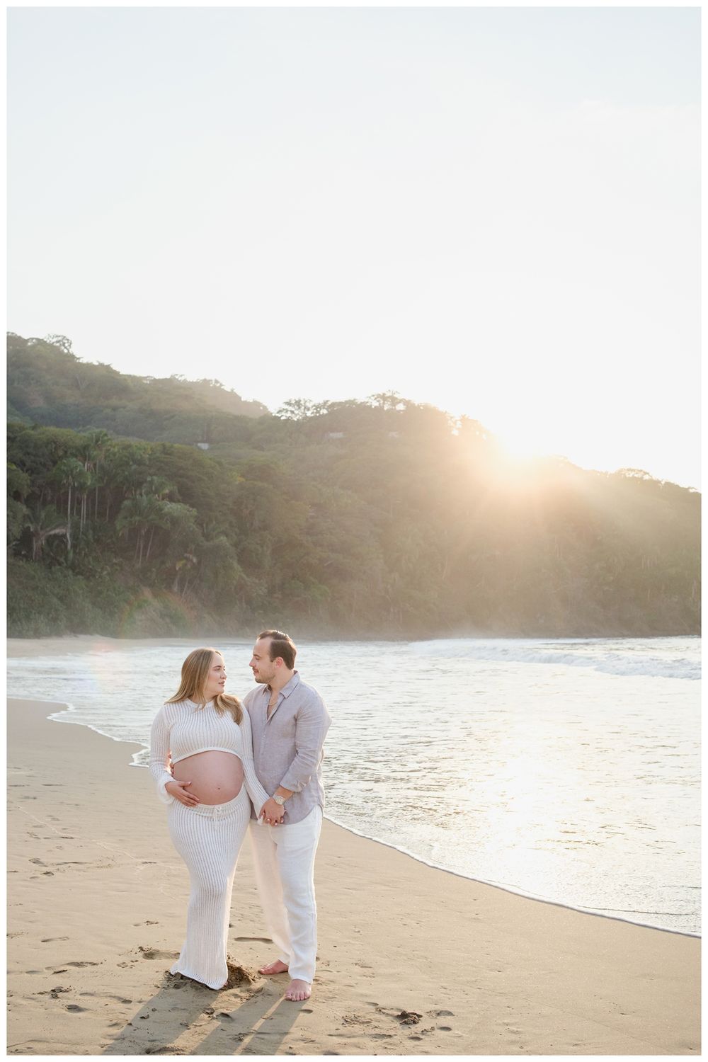 One & Only Mandarina family photographer capturing beach family photos with an expecting couple at sunset.