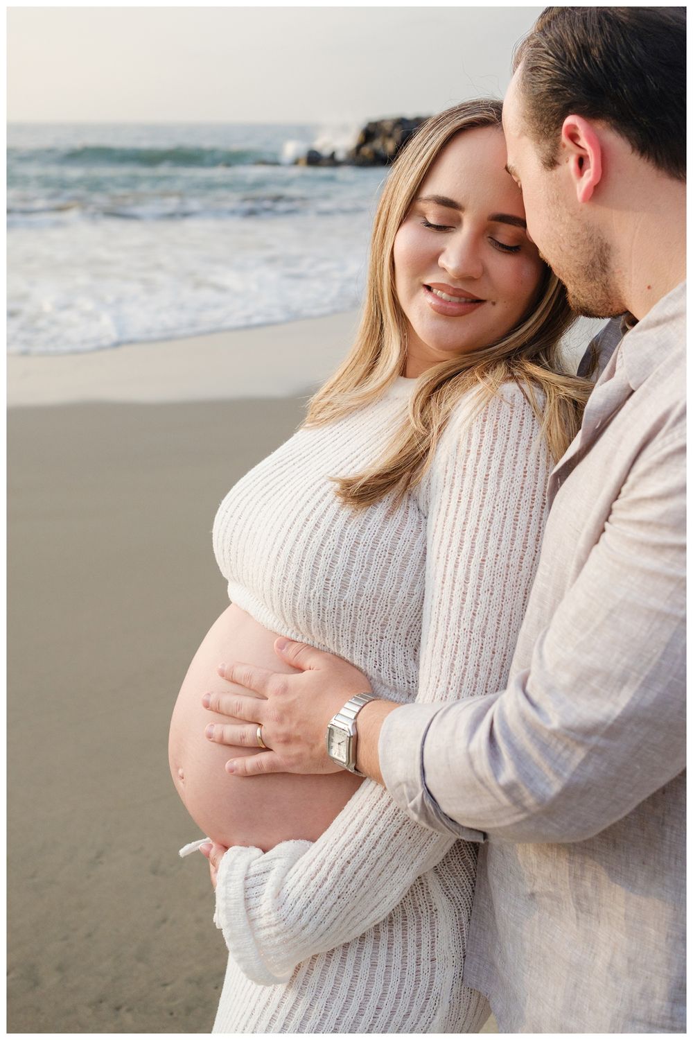 One & Only Mandarina family photographer capturing maternity photos as a couple celebrates pregnancy on a peaceful beach.