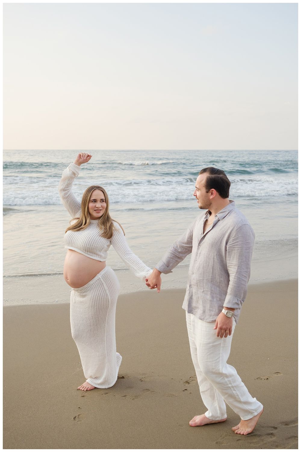 One & Only Mandarina family photographer creating maternity photos of a couple during a golden hour beach session.