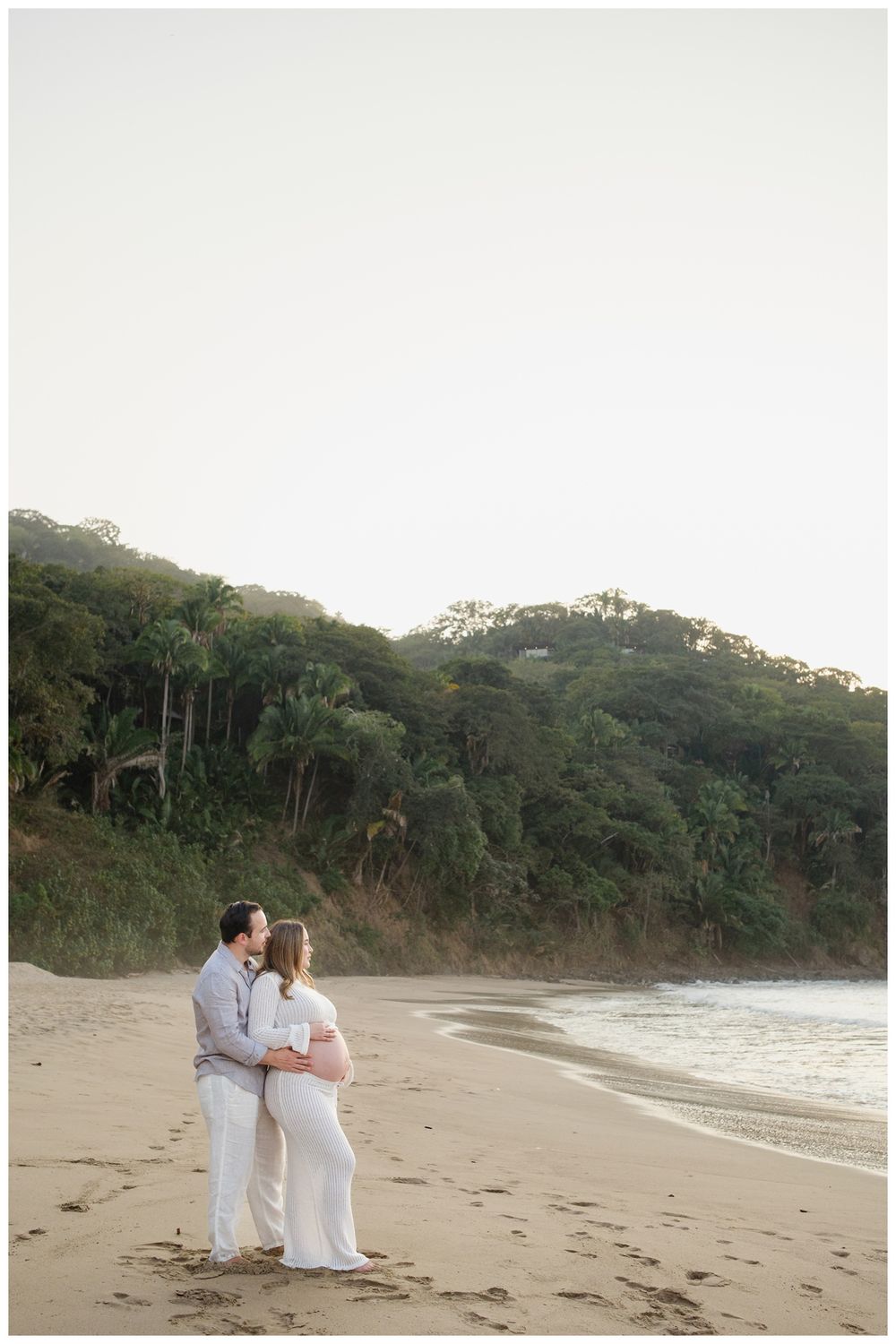 One & Only Mandarina family photographer documenting a maternity photoshoot with a couple enjoying a golden hour beach moment.