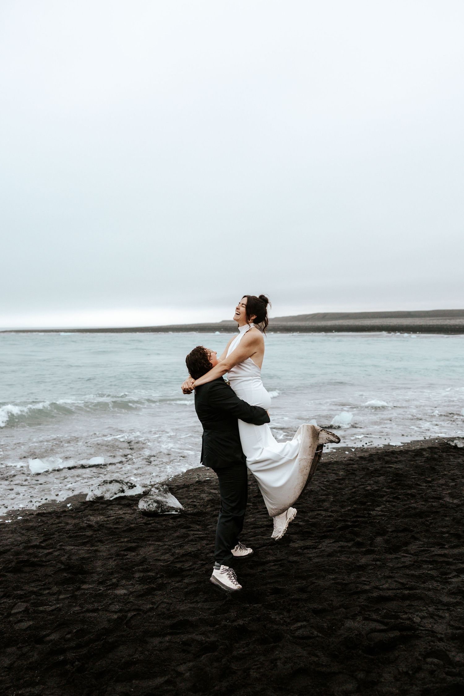 beautiful moment of bride picking up her bride at diamond beach, iceland