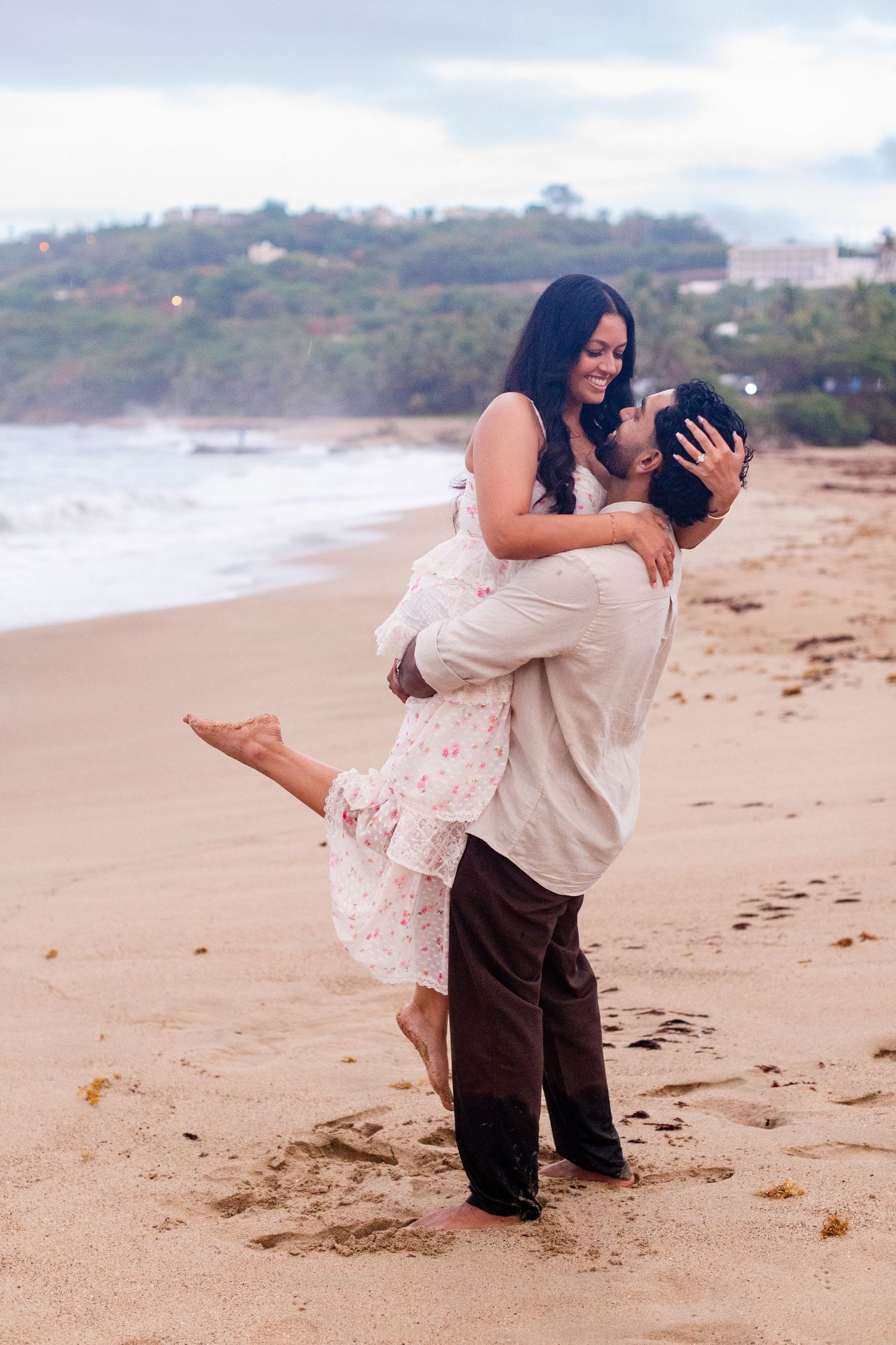 Engagement portrait on the beach. Man lifting woman. Playa Guajataca, Isabela, Puerto Rico.