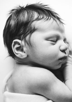 Black and white close-up portrait of a peacefully sleeping newborn baby