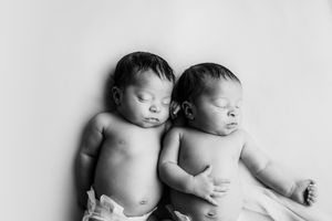 Black and white portrait of newborn twins lying together