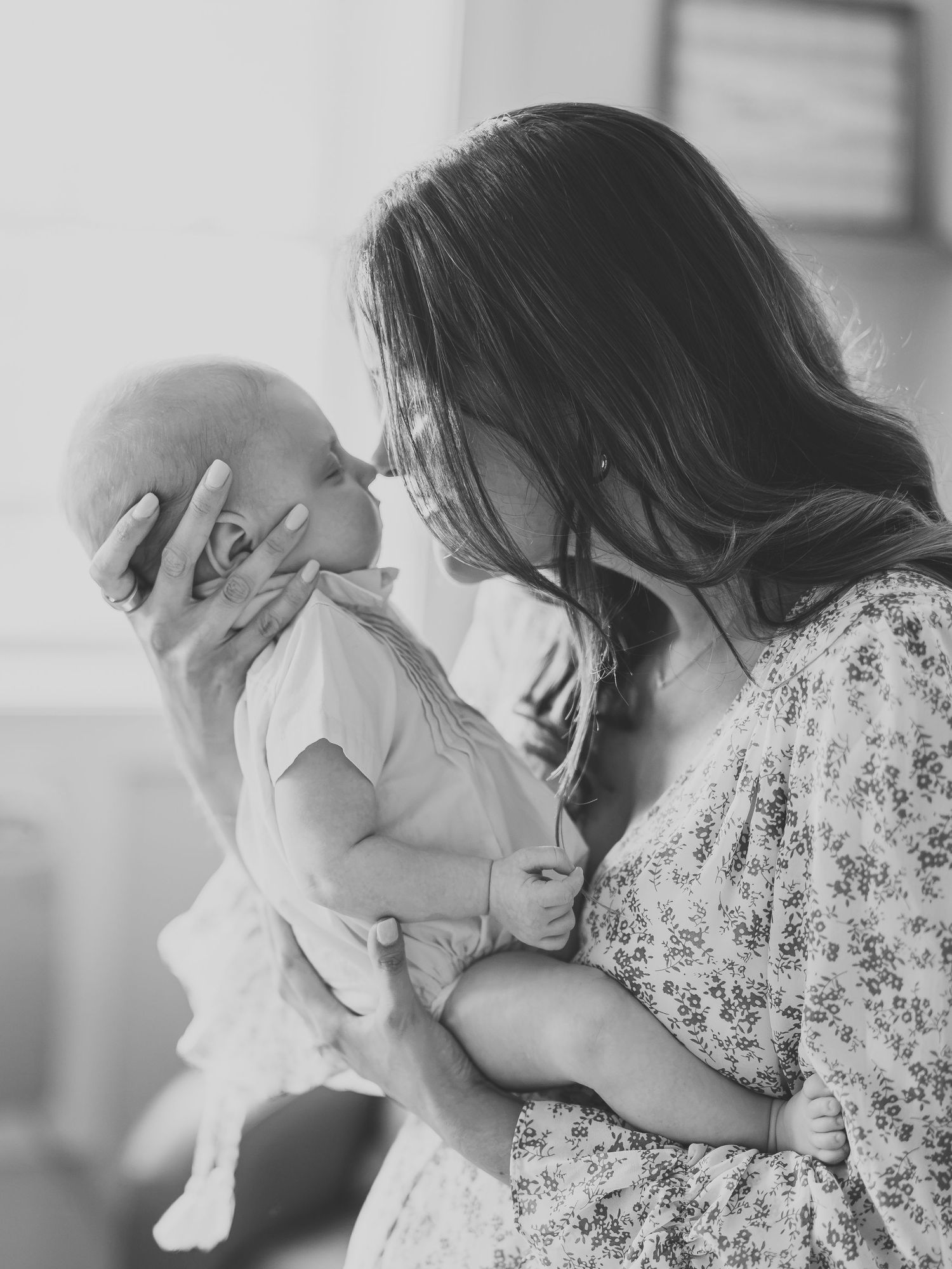 Black and white image of mother nose to nose with her baby boy.