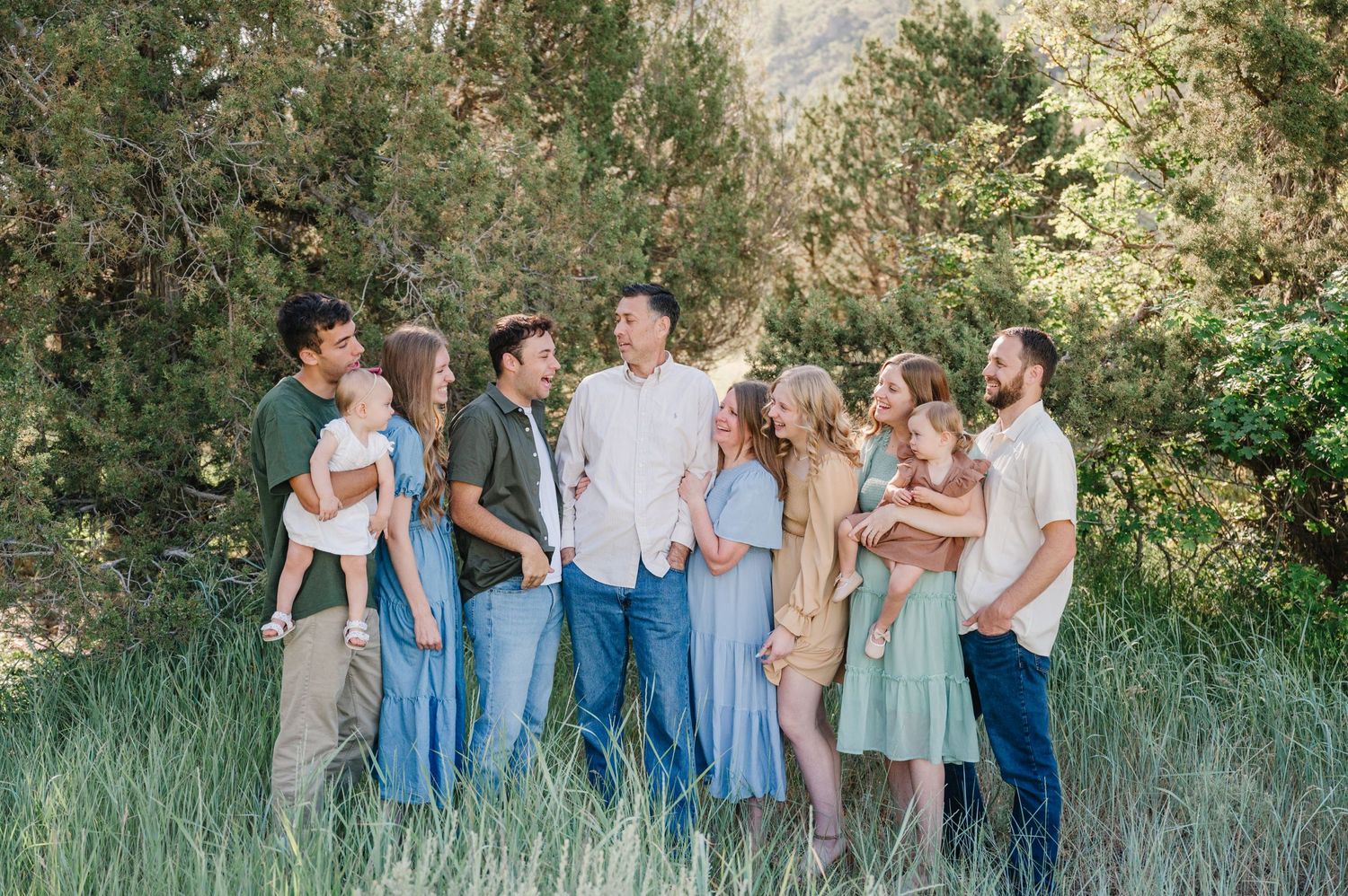 Casual outdoor family gathering with group members wearing coordinated outfits in natural mountain setting.