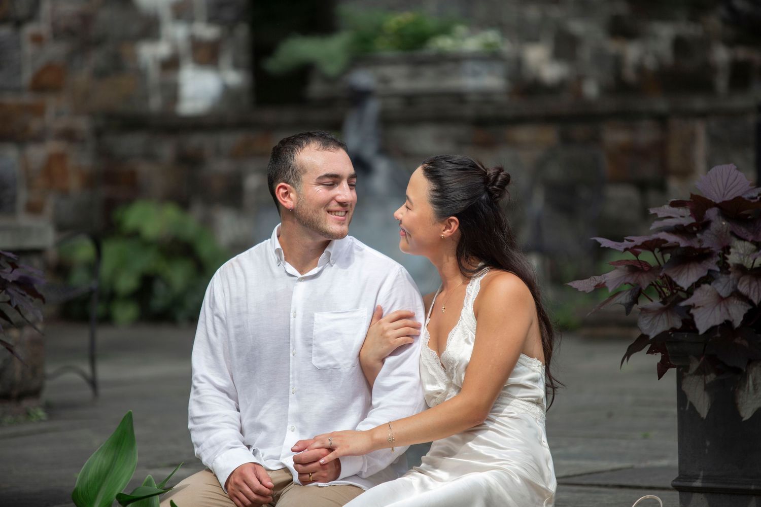 Romantic couple sharing an intimate moment outdoors, backlit by golden sunset light in a tender close-up portrait.
