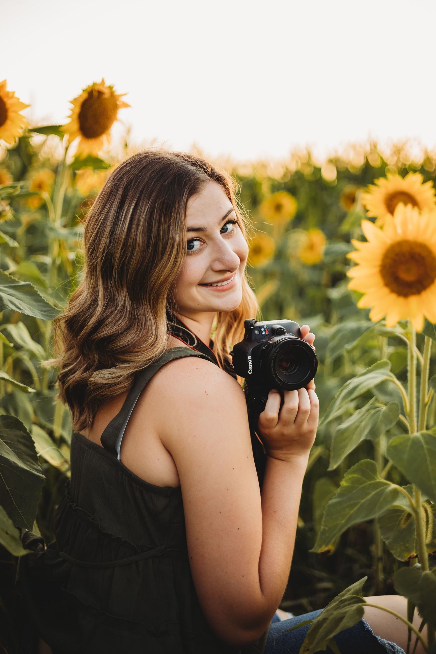 The photographer with her camera in a field of sunflowers.