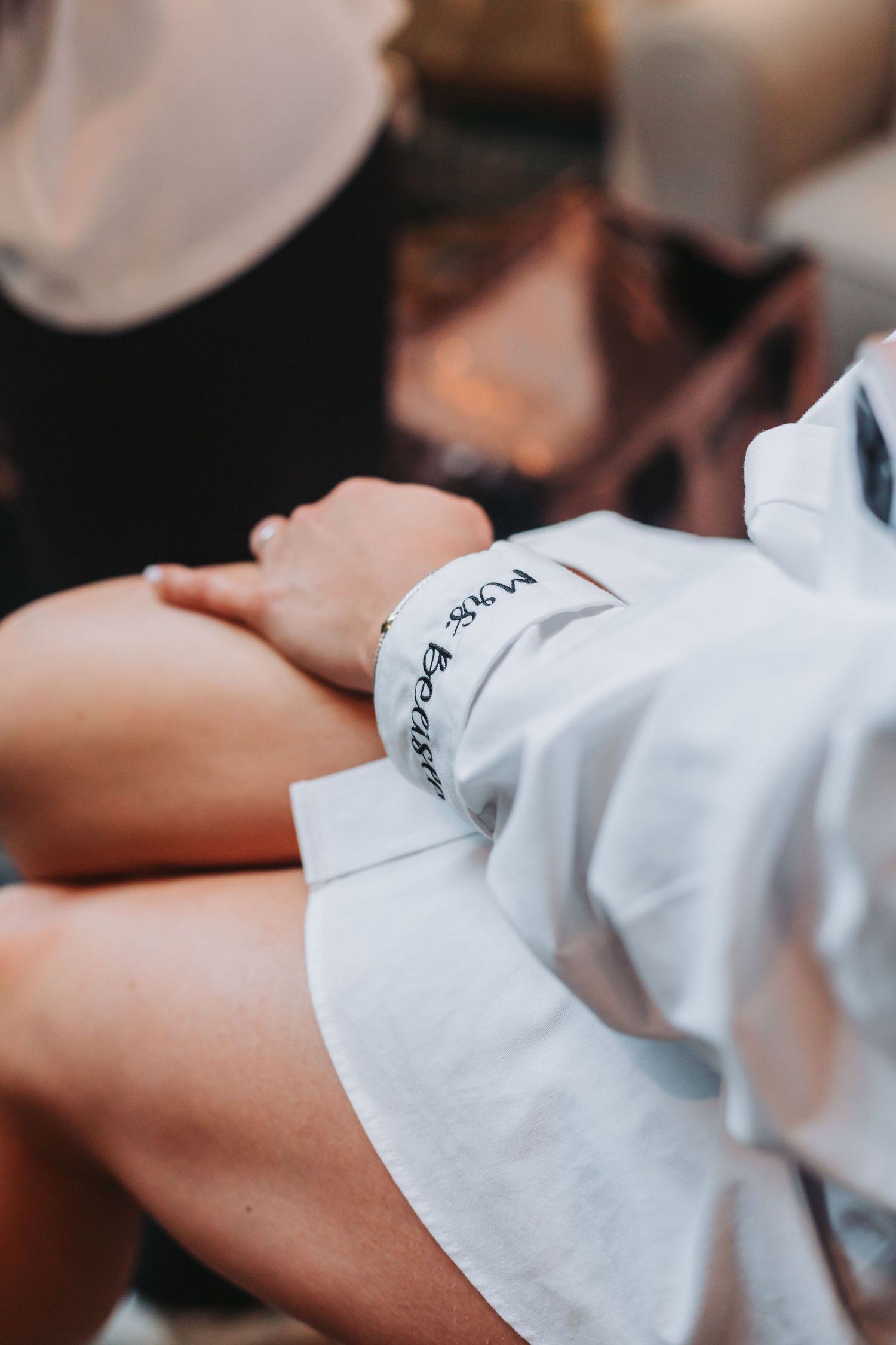 Close-up of a bride wearing a white Mrs. bracelet on her wrist during wedding preparations.