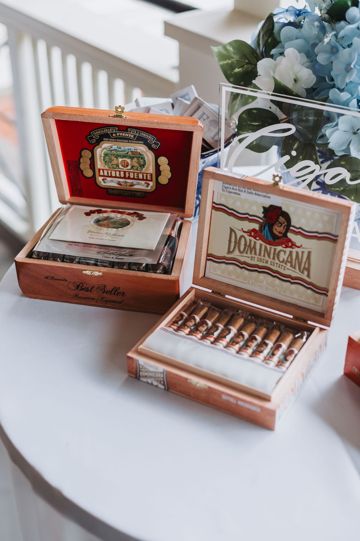 Two open cigar boxes featuring Arturo Fuente and Dominicana cigars displayed at a wedding reception.