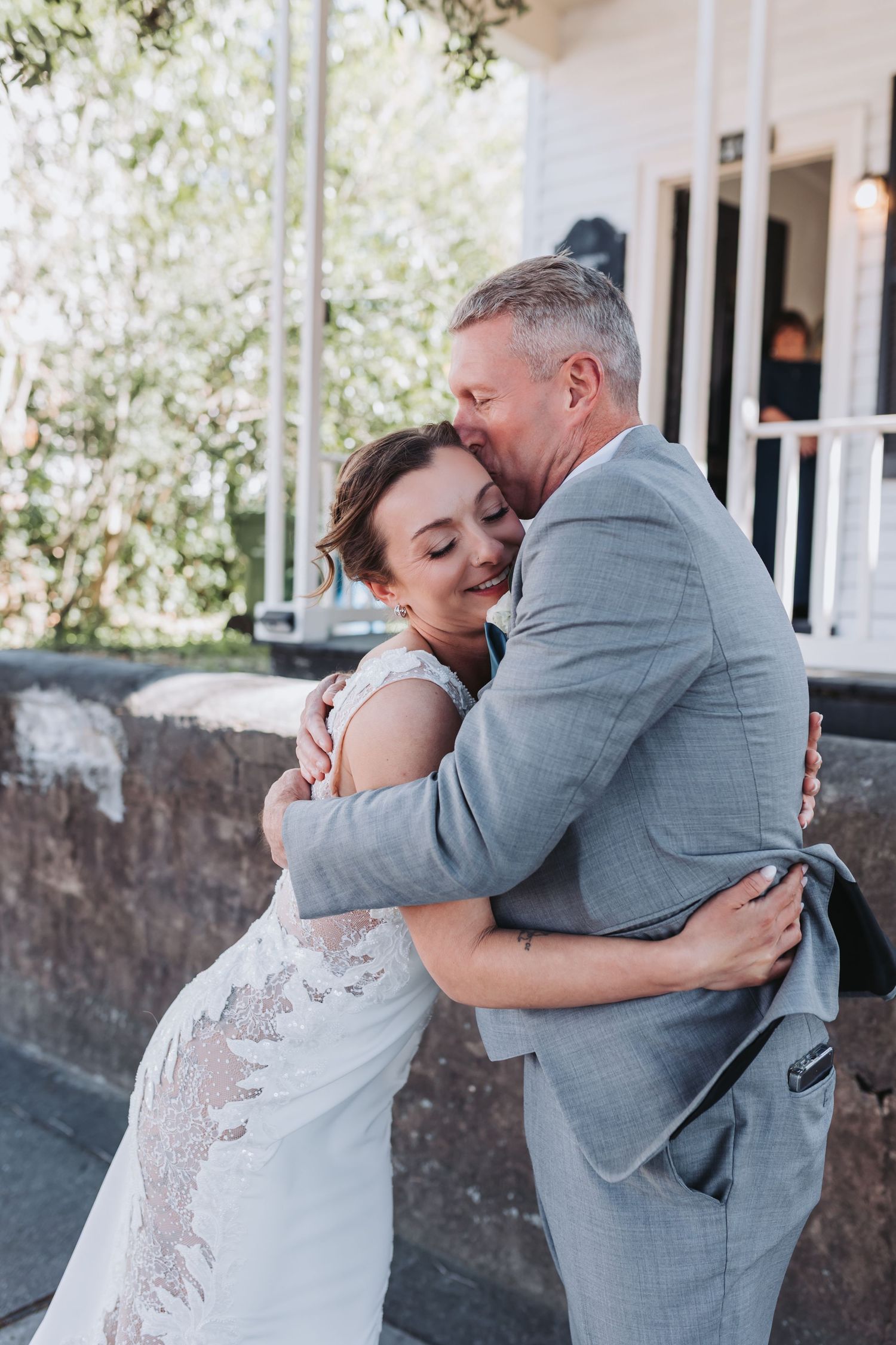 Bride and groom sharing an emotional embrace during first look outside a historic venue.