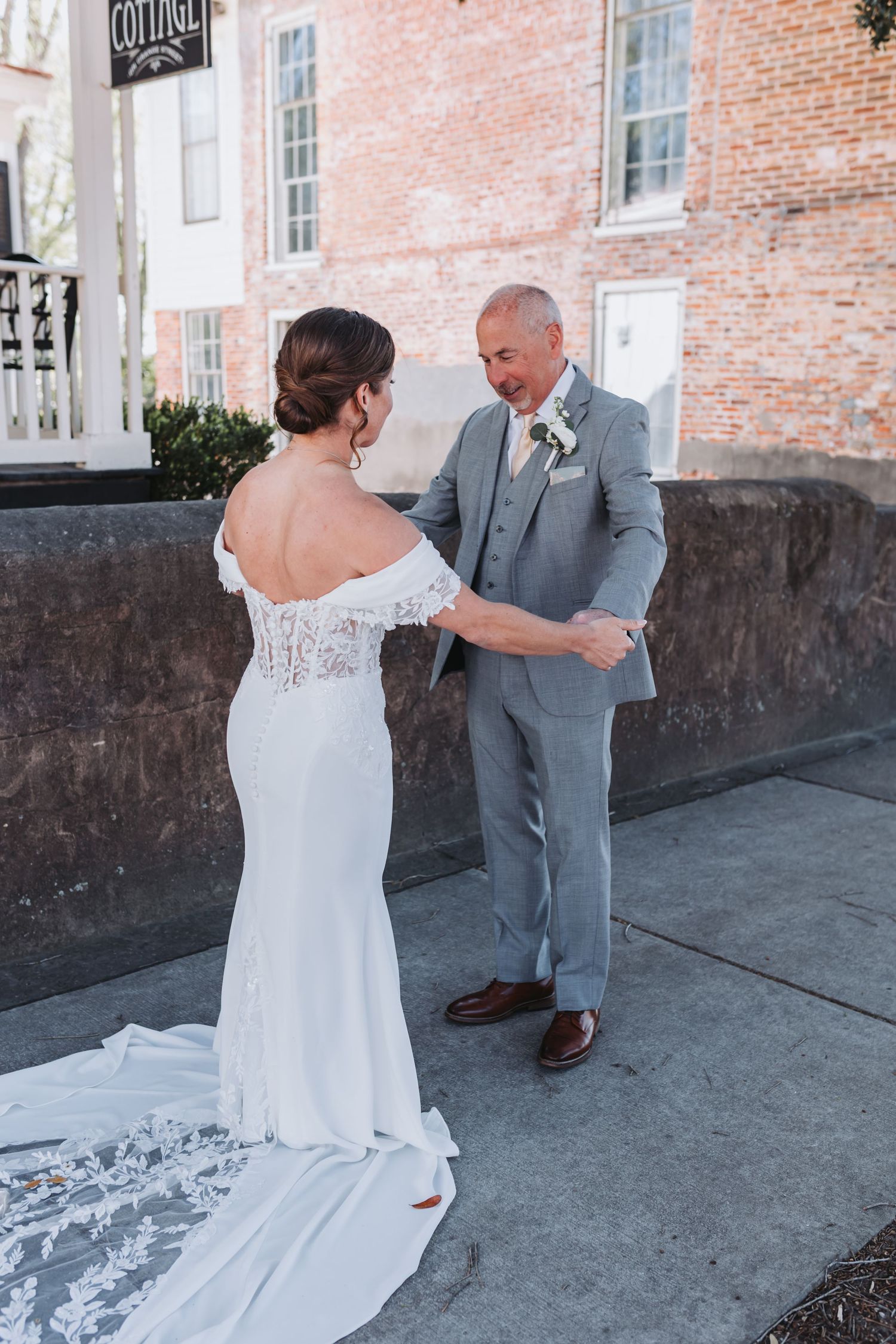 Bride and groom share first look moment outside historic brick building on wedding day.