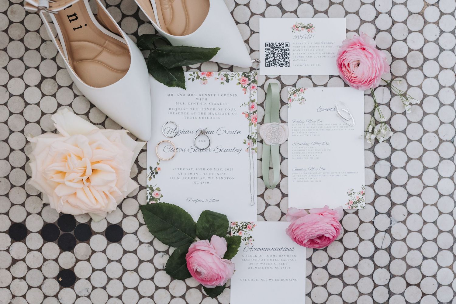 Elegant wedding stationery suite with floral details, pink roses, and white heels on a hexagon tile background.