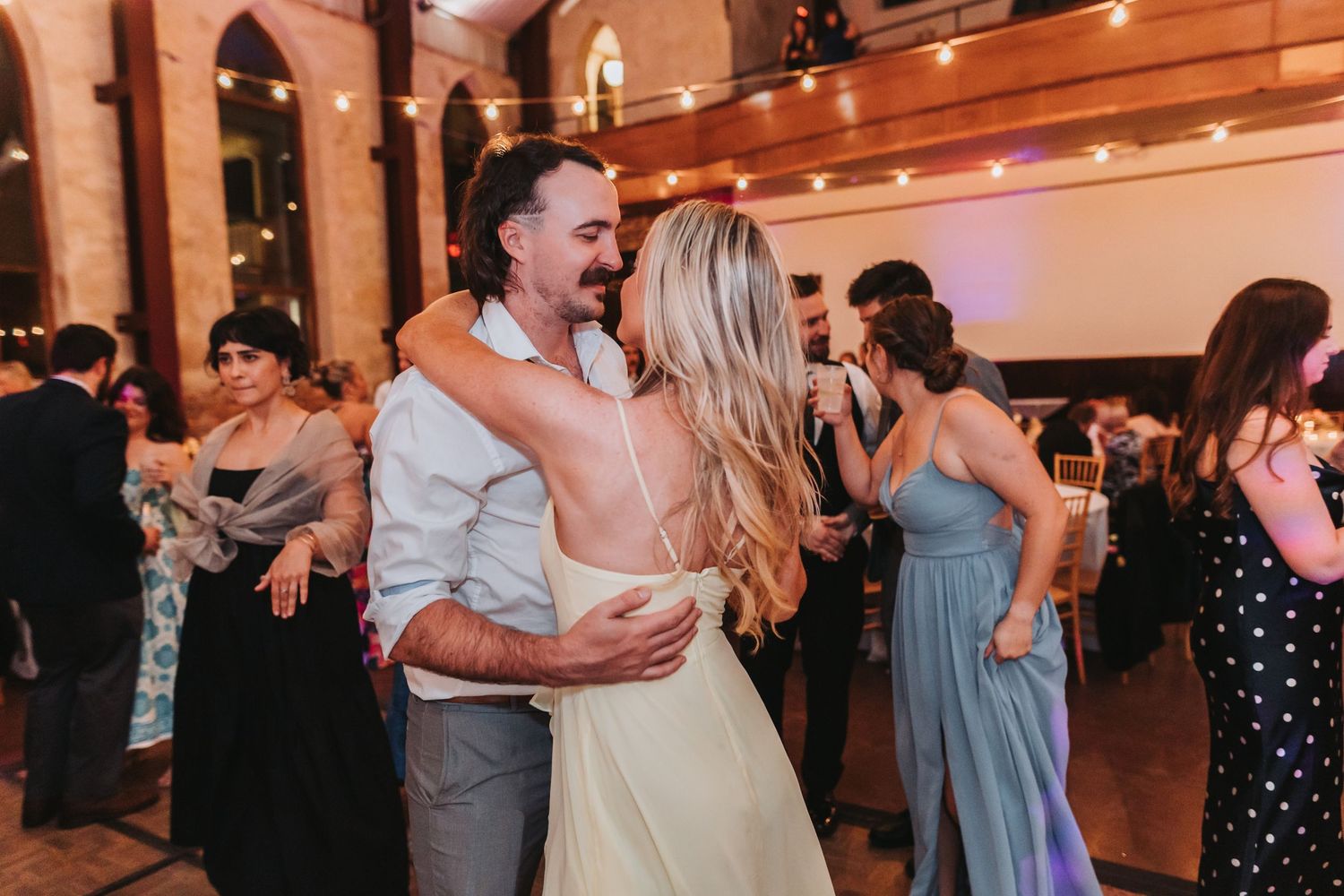 Bride and groom share a romantic dance together on the wedding reception dance floor.