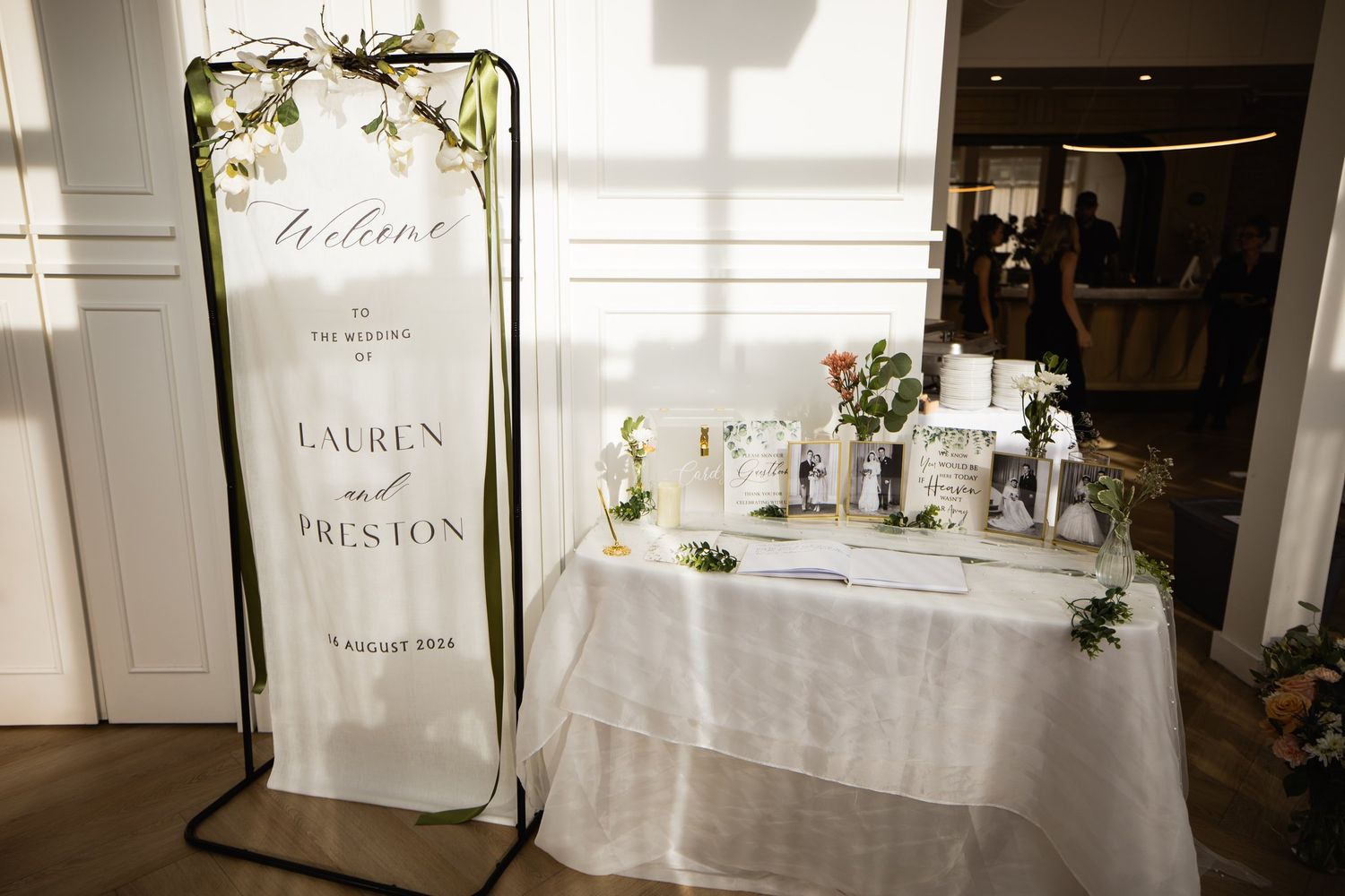 Lauren and Preston welcome sign and guest book table with family wedding photos at Studios at Vic Park in Calgary