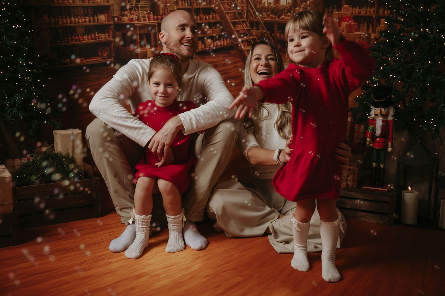 A family of four together in a warm Christmas setting, photographed during a previous session.