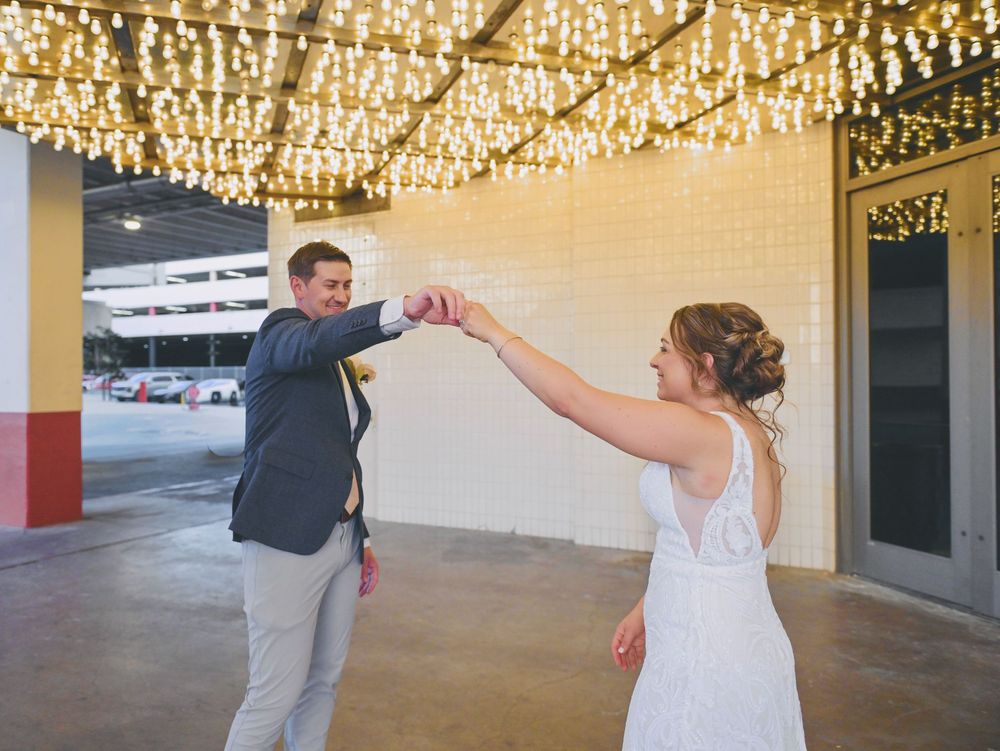 Bride and groom share a playful fist bump under sparkling string lights at their Las Vegas wedding venue.